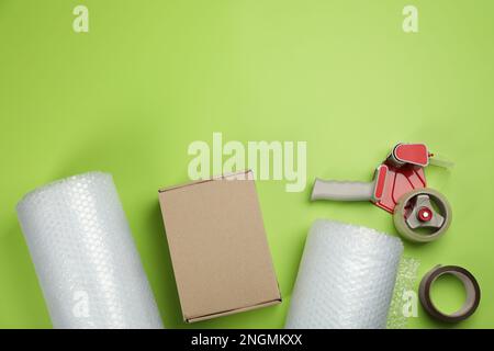 Flat lay composition with bubble wrap rolls on green background, space for text Stock Photo