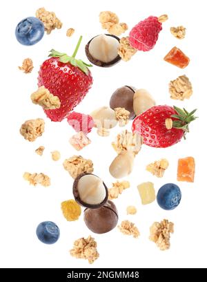 Delicious granola, nuts and berries falling on white background. Healthy snack Stock Photo