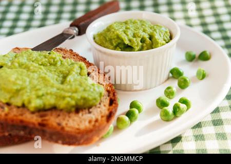 A hearty bread spread made from fresh peas, onion and garlic. Stock Photo