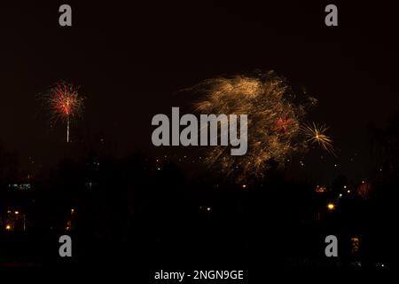 Fireworks display against buildings and dark sky in the city on New Year's Eve. Rybnik, Poland Stock Photo