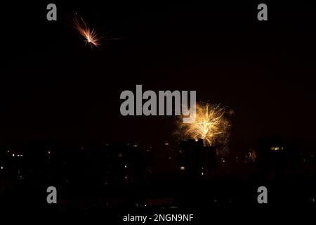 Fireworks display against buildings and dark sky in the city on New Year's Eve. Rybnik, Poland Stock Photo