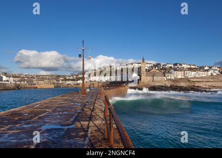 Waves roll into Porthleven reef on a bright winter's day, Cornwall Stock Photo