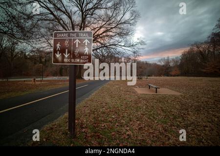 A multi-use trail sign and exercise course in Washington, DC’s Rock Creek Park, seen on a winter day at sunset. Stock Photo