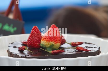 Chocolate cake with chilli and strawberries at the Naplavka farmers street food market on the waterfront of the Vltava River in Prague. Stock Photo