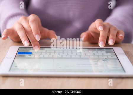 Hands on digital tablet keyboard close up girl working office work remotely typing text, woman using notepad computer Distance learning online Stock Photo