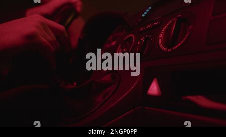 Close-Up of Male Driver's Hand Pushing the Flashing Hazard Lights Button in a Car Interior, Highlighting the Importance of Road Safety, Emergency - Stock Photo