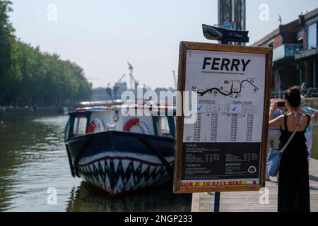 A Ferry with a sharks face painted on it- in Bristol, with a sign showing boat times Stock Photo