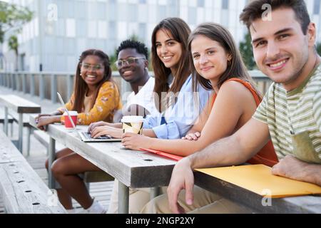 Group of cheerful students together posing happily looking at camera outdoors. Portrait people. Stock Photo