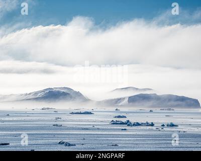 Fog over huge icebergs from the Ilulissat Icefjord stranded on a former terminal moraine in Ilulissat, Greenland. Stock Photo