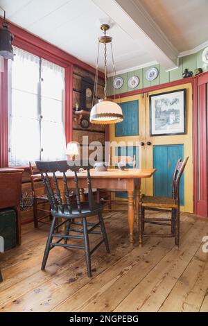 Pine wood dining table with assorted chairs in kitchen with worn wide ...