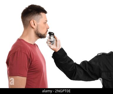 Police inspector conducting alcohol breathe testing, man blowing into breathalyzer on white background Stock Photo