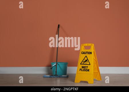 https://l450v.alamy.com/450v/2ngptkf/safety-sign-with-phrase-caution-wet-floor-mop-and-bucket-indoors-cleaning-service-2ngptkf.jpg