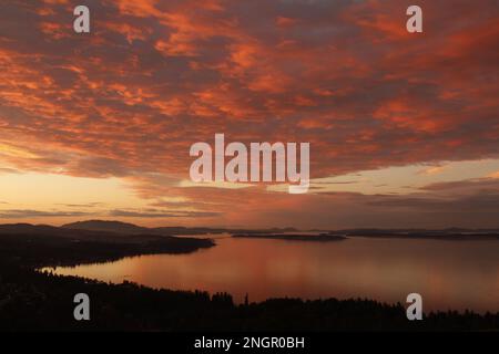 A dramatic sunset with pink and blue clouds over Cordova Bay. Taken from Mount Douglas on Vancouver Island, BC, Canada. Stock Photo
