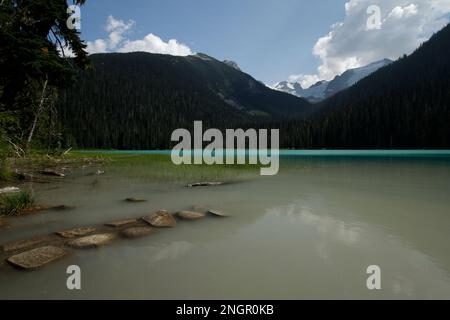 Lower Joffre Lake in Joffre Lake Provincial Park, BC, Canada. A stone pathway leads into the water. Stock Photo