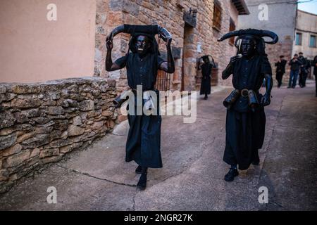 Luzon, Spain. 18th Feb, 2023. People dressed as 'Devils of Luzon' during the carnival celebration that runs through the streets of the town of Luzon. The festival of the 'Devils of Luzon' is an ancestral celebration. The Devils are covered in oil and soot, on their heads they wear bull horns, their teeth are made of potatoes, they wear a cowbell attached to their belt and scare the inhabitants. Credit: SOPA Images Limited/Alamy Live News Stock Photo