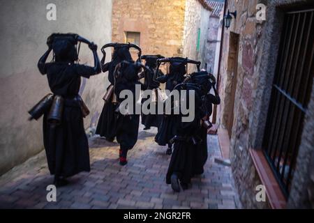 Luzon, Spain. 18th Feb, 2023. People dressed as 'Devils of Luzon' during the carnival celebration that runs through the streets of the town of Luzon. The festival of the 'Devils of Luzon' is an ancestral celebration. The Devils are covered in oil and soot, on their heads they wear bull horns, their teeth are made of potatoes, they wear a cowbell attached to their belt and scare the inhabitants. (Photo by Luis Soto/SOPA Images/Sipa USA) Credit: Sipa USA/Alamy Live News Stock Photo