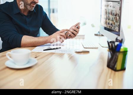 If you have the right contacts, you have everything. an unrecognizable businessman using his cellphone at his desk. Stock Photo