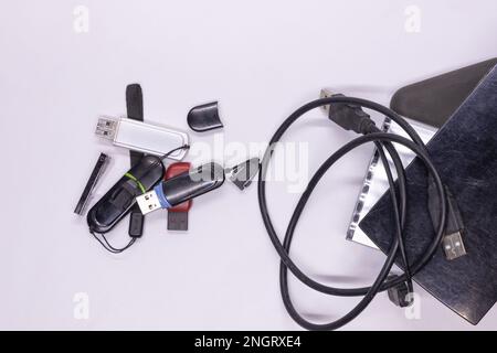 Pen drives also called flash drives used to store data from computer kept along with hard disk drives and solid-state drives on a white background. Stock Photo