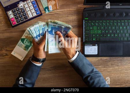 Business man hand counting Pakistani currency notes for budget Saving money investment and financial accounting management or growing business concept Stock Photo