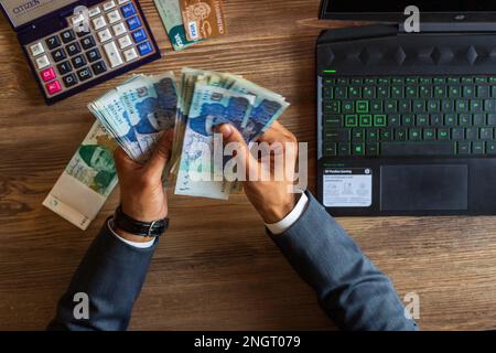 Business man hand counting Pakistani currency notes for budget Saving money investment and financial accounting management or growing business concept Stock Photo