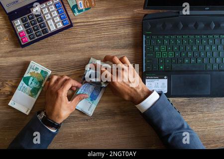 Business man hand counting Pakistani currency notes for budget Saving money investment and financial accounting management or growing business concept Stock Photo