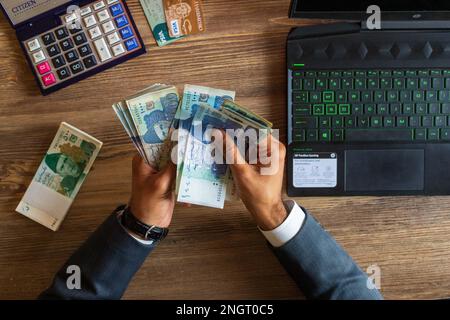 Business man hand counting Pakistani currency notes for budget Saving money investment and financial accounting management or growing business concept Stock Photo