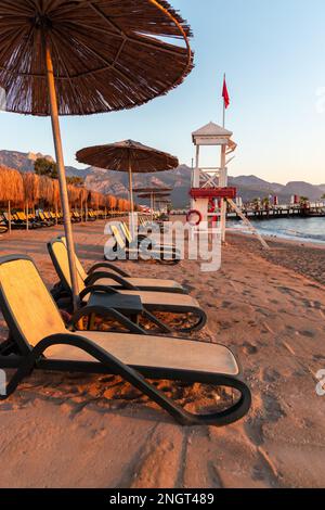 Empty beach with sun loungers and umbrellas in the early morning on a sunny day in Belek, Antalya, Turkey. Stock Photo