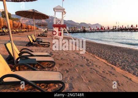 Empty beach with sun loungers and umbrellas in the early morning on a sunny day in Belek, Antalya, Turkey. Stock Photo