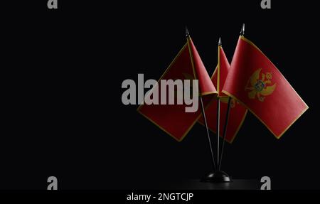 Small national flags of the Montenegro on a black background. Stock Photo