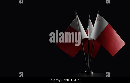 Small national flags of the Malta on a black background. Stock Photo