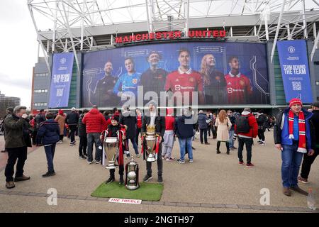 Fans pose with replica trophies ahead of the Premier League match at Old Trafford Stadium, Manchester. Picture date: Sunday February 19, 2023. Stock Photo