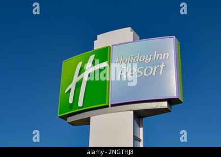 Galveston, Texas - February 2023: Sign outside the Holiday Inn Beach resort against a deep blue sky Stock Photo