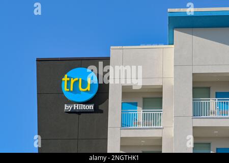 Galveston, Texas - February 2023: Sign on the outside of the Tru hotel, which is part of the Hilton chain of hotels Stock Photo