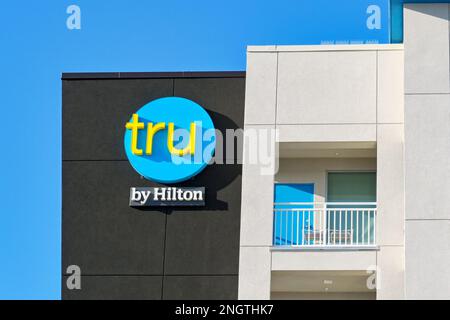 Galveston, Texas - February 2023: Sign on the outside of the Tru hotel, which is part of the Hilton chain of hotels Stock Photo