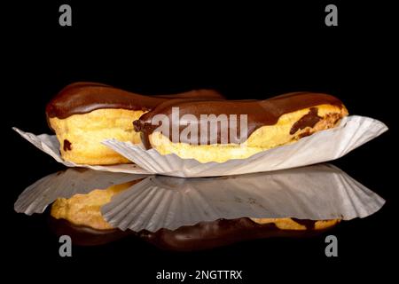 Two chocolate eclairs, macro, isolated on black background. Stock Photo