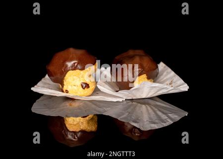 Two chocolate eclairs, macro, isolated on black background. Stock Photo