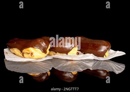 Three chocolate eclairs, macro, isolated on black background. Stock Photo