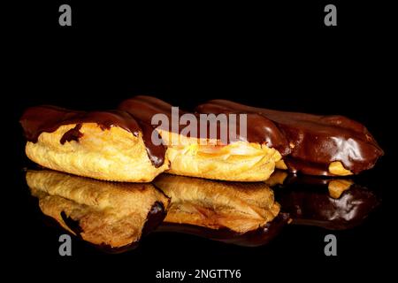 Three chocolate eclairs, macro, isolated on black background. Stock Photo