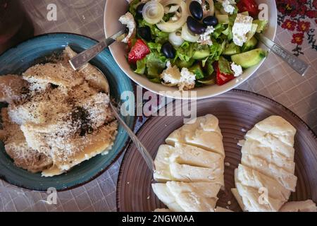 Greek Village Salad, umplings sprinkled with cheese and Halloumi cheese in restaurant in Cyprus island country Stock Photo