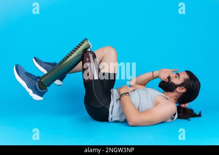 Man with a prosthetic leg doing sit-ups Stock Photo