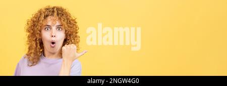 Woman with curly hair pointing surprised to the side Stock Photo