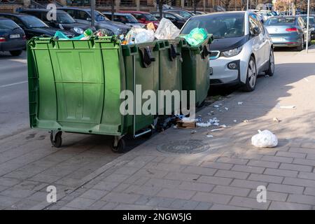 Overflowing trash cans on street in city. Problem rubbish disposal. Stock Photo