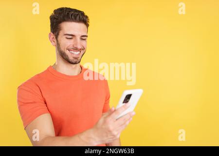Happy caucasian man smiling while using the mobile Stock Photo