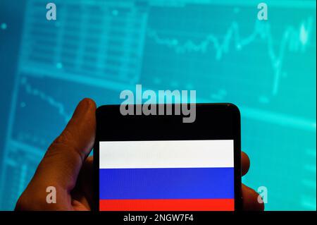 China. 19th Feb, 2023. In this photo illustration, the Russian Federation flag is seen displayed on a smartphone with an economic stock exchange index graph in the background. (Photo by Budrul Chukrut/SOPA Images/Sipa USA) Credit: Sipa USA/Alamy Live News Stock Photo