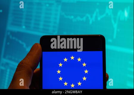 China. 19th Feb, 2023. In this photo illustration, the European Union (EU) logo is seen displayed on a smartphone with an economic stock exchange index graph in the background. (Photo by Budrul Chukrut/SOPA Images/Sipa USA) Credit: Sipa USA/Alamy Live News Stock Photo