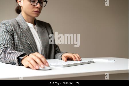 Businesswoman working on pc with blank virtual monitor using wireless keyboard and computer mouse, space for photomontage insert infographic. Stock Photo