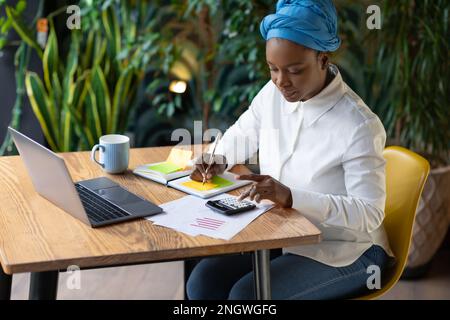 Black woman working at cafe, using laptop, copy space Stock Photo
