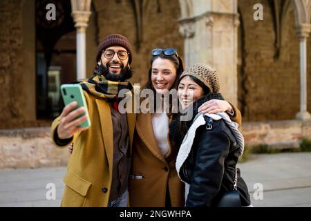 happy Multiracial group of friends making a selfie with phone in holidays, focus on the man - friendship, happiness and joyful concept Stock Photo