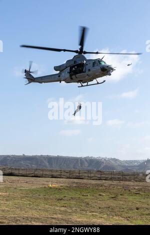 U.S. Marines with Marine Light Attack Helicopter Squadron 169, Marine Aircraft Group 39, 3rd Marine Aircraft Wing (MAW), lift U.S. Navy Master Chief Petty Officer Ryan Grant, a departmental leading chief petty officer with Helicopter Sea Squadron 3, during exercise Steel Knight 23, at Imperial Beach, California, Nov. 29, 2022. The exercise provides 3rd MAW an opportunity to refine Wing-level warfighting in support of I Marine Expeditionary Force and fleet maneuver. Stock Photo