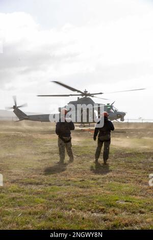 U.S. Navy Master Chief Petty Officer Ryan Grant, a departmental leading chief petty officer, left, and U.S. Navy Lt. Amanda Graham, an MH-60S Seahawk pilot with Helicopter Sea Combat Squadron 3, observe a UH-1Y Venom take off during exercise Steel Knight 23 by Imperial Beach, California. Nov. 29, 2022. The exercise provides 3rd MAW an opportunity to refine Wing-level warfighting in support of I Marine Expeditionary Force and fleet maneuver. Stock Photo